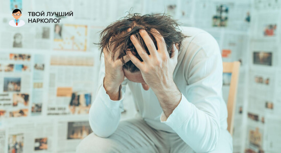 мужчина держится за голову